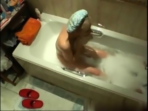 Busty mature blonde fingers her hungry pussy in the bathtub